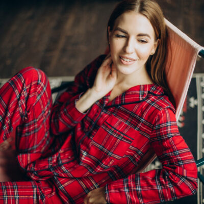 Young woman in christmas pyjamas sitting on chair