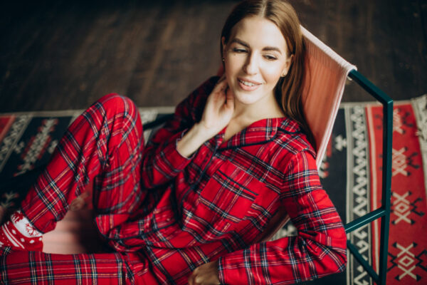 Young woman in christmas pyjamas sitting on chair